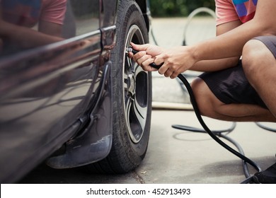 Man Asia Driver Checking Air Pressure And Filling Air In The Tires Of Car