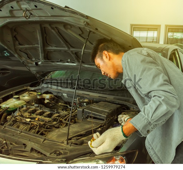 Man asian Car checking  inspection to\
To take a photo for fix Repair from the application.To send to the\
database To help the car While the car is\
broken