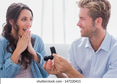Man asking his partner to marry him by offering to her an engagement ring