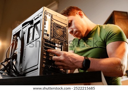 Man assembles a computer system unit at home