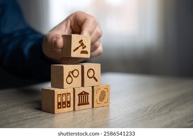 A man assembles a judicial system from blocks in the shape of a pyramid. Legal hierarchy, law enforcement, and justice system organization.