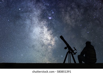 Man with astronomy  telescope looking at the stars. Man telescope and starry sky. Night sky. Milky way galaxy.