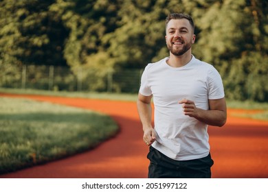 Man athlete jogging at stadium in the morning - Shutterstock ID 2051997122