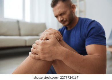 Man athlete pain and injury back arm and leg at home, sports injury bodybuilder, concept health and beauty - Powered by Shutterstock