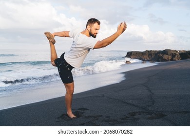 Man Athlete With Perfect Pumped Up Figure Recreating Doing Yoga Poses Feeling Inner Peace And Vitality, Male With Flexible Body Standing In Asana Care About Physical And Mental Health