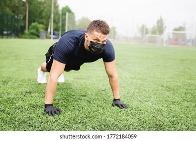 Man Athlete Pressed Plank Exercise Endurance Green Field Power Day Light Male In Black Mask Gloves.