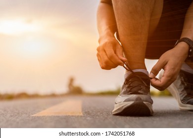 A man athlete tying shoelaces on shoes. close-up hand sneakers smart bracelet watches.concept of a healthy lifestyle, freedom. - Shutterstock ID 1742051768