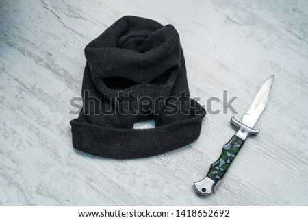 man attack with knife. The guy with knife in hand wearing a black hood. The threat of a cold weapon. The concept of crime and robbery. place of crime, crime scene,