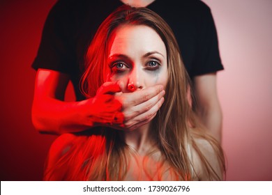 A man attacks a woman, domestic violence. The guy closed the girl's mouth and threatened. Drunk husband beats his wife. An aggressive man hits and strangles with a belt. The frightened girl is crying.