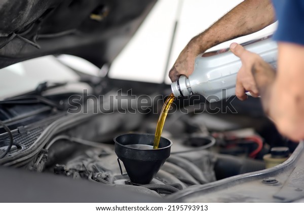 Man auto mechanic\
repairs car in autoservice, station. Changes oil. Diagnostics,\
maintenance and repair.