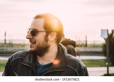 Man In Aviator Sunglasses Smiling, Shining Light Behind Him