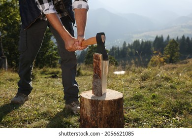 Man with axe cutting firewood in mountains, closeup - Powered by Shutterstock