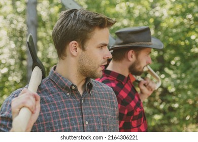 Man with axe in forest. Lumberjack woodcutter in a plaid shirt. Lumberjack brutal bearded man