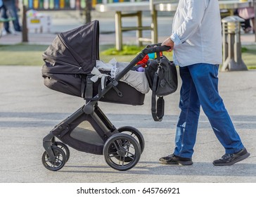 Man With A Baby Stroller On A Walk