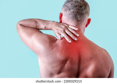 A Man With Back Pain At Home, On A Blue Background. Myalgia, Arthritic Joint Pain. Copy Space