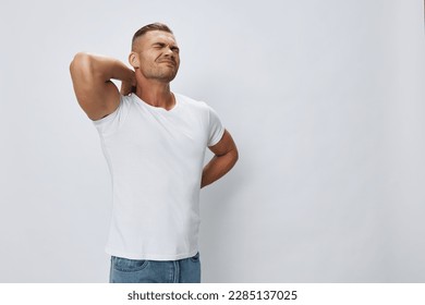 Man back pain neck and joints, bone and spine problems, inflammation and trauma, in white T-shirt on white isolated background, copy space - Powered by Shutterstock