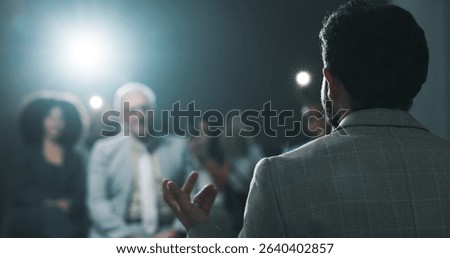Man, back of speaker or presentation for press conference, development seminar or business event. Audience, speech and workshop for economy talk in auditorium with flare, keynote and summit forum
