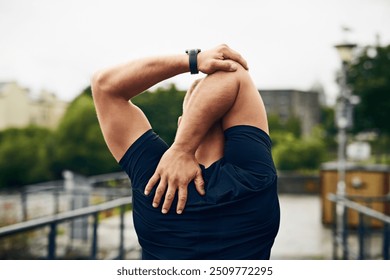 Man, back and stretching arms for fitness, exercise and health with music, preparation and ready. Athlete, development and warm up outdoor for workout, training and morning run with flexible body - Powered by Shutterstock