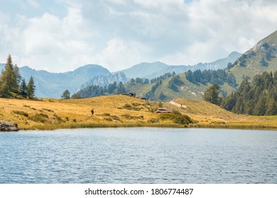 A Man In The Background Is Walking Towards The Mountains. Concept For Solo Hiking, Mountain Hike, Solo Trip, Travel Among The Nature.