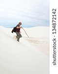 The man with the backpack down on the white dunes of gypsum squeak. White Sands National Monument, New Mexico