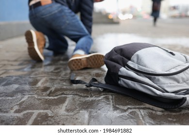 Man with backpack felling on slippery sidewalk in winter closeup