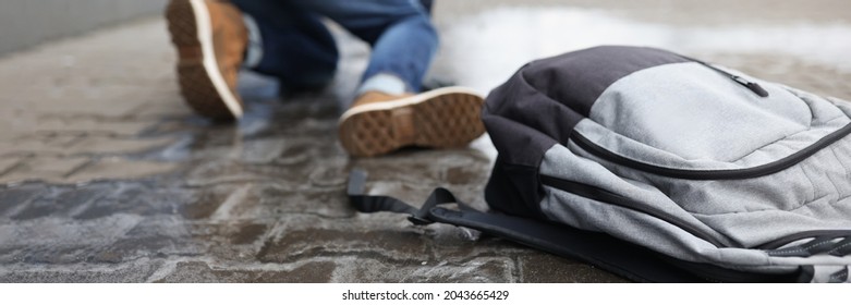 Man With Backpack Felling On Slippery Sidewalk In Winter Closeup