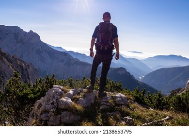 Man with backpack hiking in the scenic region of the Hochschwab mountain in Styria, Austria, Europe. Mystical blue hills in the valley in Austrian Alps. Hike concept. Freedom, fresh air. Sunny summer
