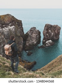 Man with a backpack on the edge of a cliff