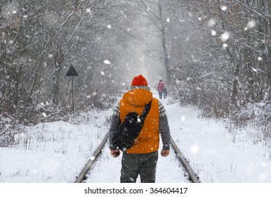 Man with backpack on the train tracks in winter