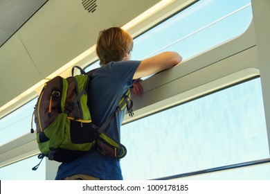 man with a backpack riding by train. traveler on the road looking out the window