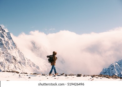 Man With Backpack Trekking In Mountains. Cold Weather, Snow On Hills. Winter Hiking.