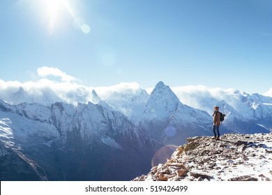Man with backpack trekking in mountains. Cold weather, snow on hills. Winter hiking.