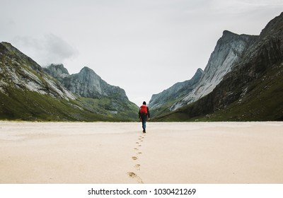 Man With Backpack Walking Away Alone At Sandy Beach In Mountains Travel Lifestyle Concept Adventure Outdoor Summer Vacations In Norway Wild Nature 
