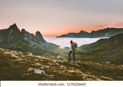 Man backpacker hiking in mountains alone  outdoor active lifestyle travel adventure vacations sunset Norway landscape