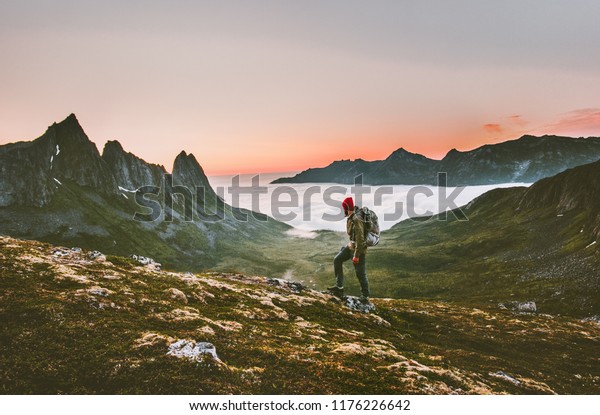 Man\
backpacker hiking in mountains alone  outdoor active lifestyle\
travel adventure vacations sunset Norway\
landscape