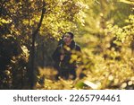 Man, backpacker and hiking in nature forest, trekking woods or trees for adventure, relax workout or fitness exercise. Japanese hiker, walking and person in environment, healthcare or cardio wellness