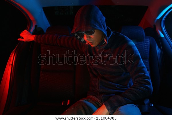 Man in the\
backseat of a car wearing a hoodie shirt Photo of a Man in the\
backseat of a car wearing a hoodie\
shirt