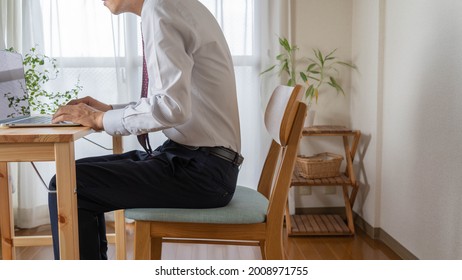A man with a bad posture. He is a businessman who works at home.