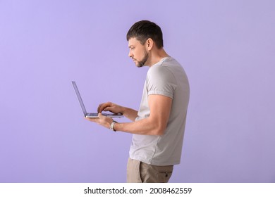 Man with bad posture using laptop on color background