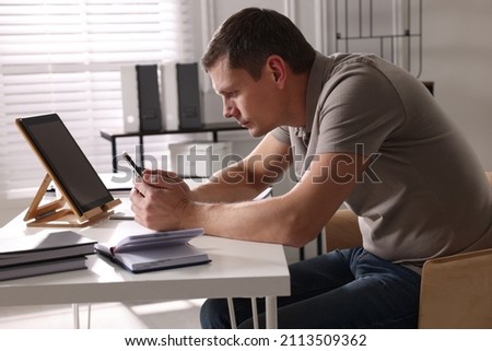 Man with bad posture using smartphone in office