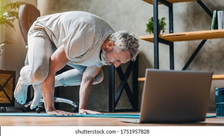 Man In Bakasana Pose Doing Vinyasa Yoga Flow At Home. Practising Yoga At Home