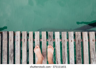 Man With Bare Fee On A Wooden Bridge,top View