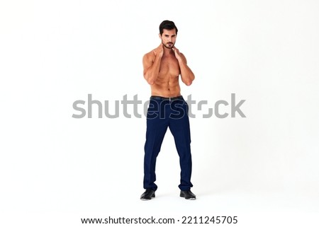Man with bare torso and prue cubes in business pants shows full-length nude body, women's day March 8 on white isolated background copy space 