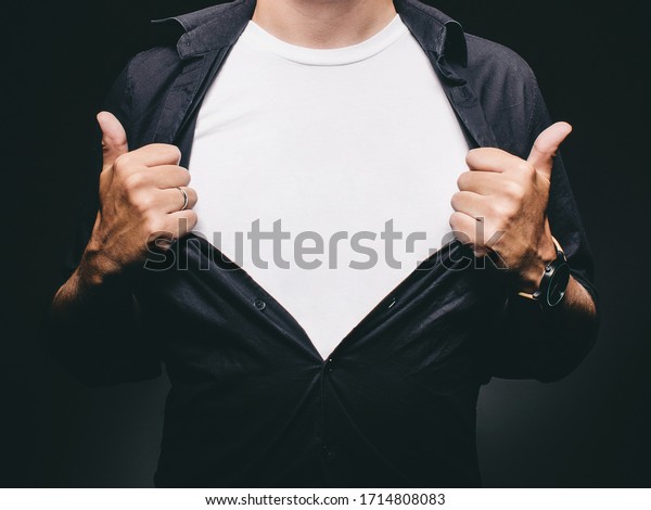 Man baring chest doing superman superhero\
pose revealing blank t-shirt with copy\
space