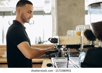 Man Barista At Coffe Shop Preparing Coffee In A Coffee Machine