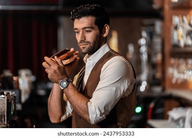 Man bartender is making a drink and dancing at bar. Dance party