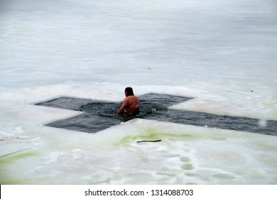 A man bathes in ice water in winter