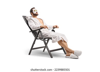 Man in a bathrobe with a face mask and cucumber on eyes sitting on a chair isolated on white background - Powered by Shutterstock