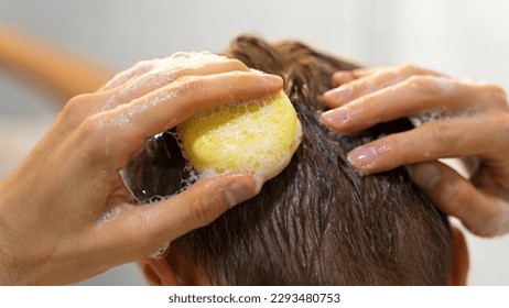 Man in the bathroom. A man applies a solid shampoo bar to the hair. Sustainable hair care, eco-friendly cosmetics. Plastic free, zero waste living, low water ingredients. Responsibility for nature. - Shutterstock ID 2293480753