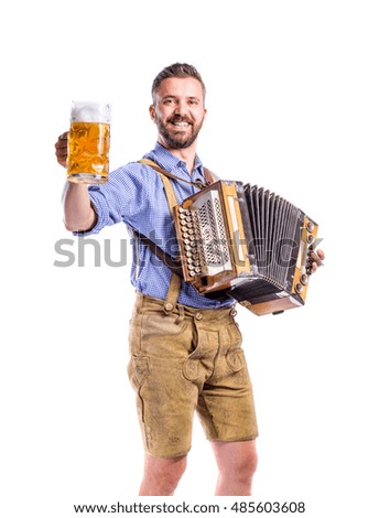 Man in bavarian clothes holding beer, playing accordion. Oktober